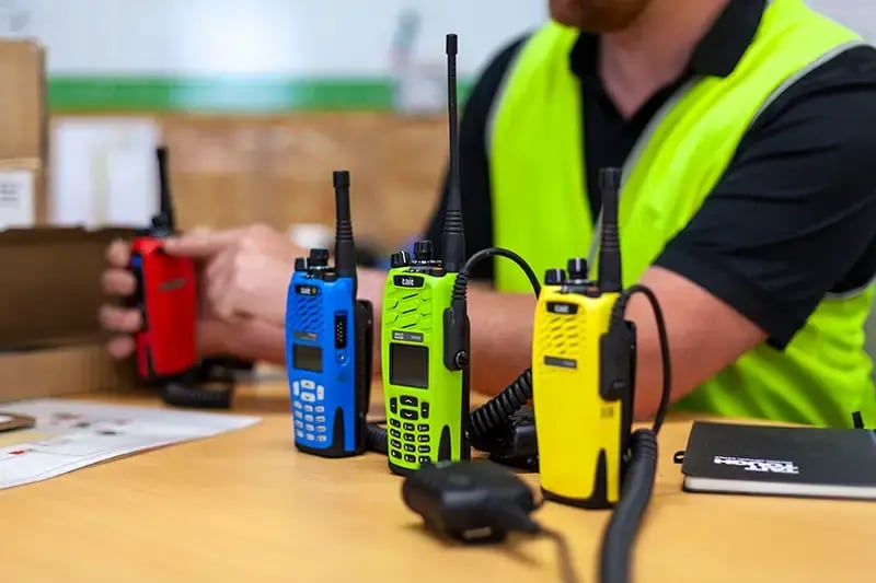 Close up of four Tait radios in a range of colors