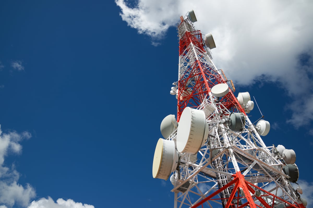A low angled shot of a radio frequency tower stretching up towards the sky. The physical location of these towers plays an important role in coverage modeling and interference mitigation during the RF design process.
