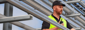 Worker in hi vis staying connected with DMR Tier 3 solutions for small to medium sized businesses.