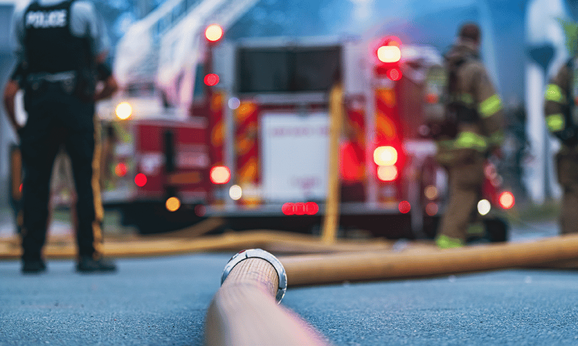 low angle view of police and firefighters responding to an emergency. Multiagency response is a key priority of P25 standards.