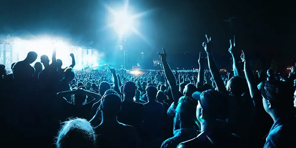 Large concert crowd at night under bright stage lights, illustrating high-density event environment where reliable communications are critical.