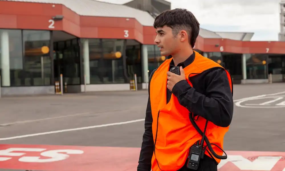 Event staff member using a handheld radio to coordinate teams and support smooth event operations.