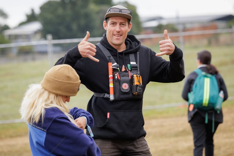 Event staff member wearing a radio harness gives a thumbs-up.