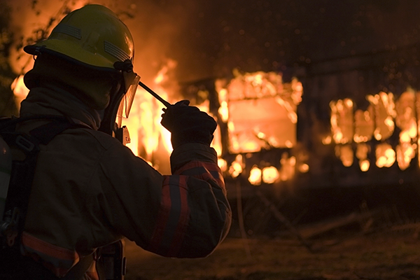A Firefighter Calling-In a House Fire