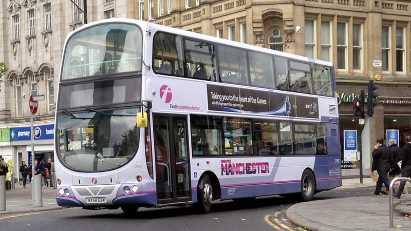 A bus in Greater Manchester pulling around and inner-city corner.