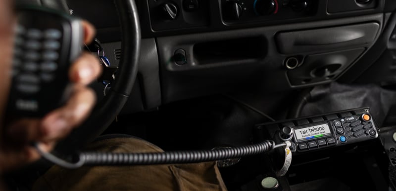 TCH4 installed in left hand drive vehicle, user's hand holding a keypad speaker mic