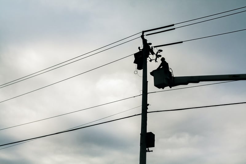 American Public Power Association Linesman inspecting a power line, transported by a cherrypicker